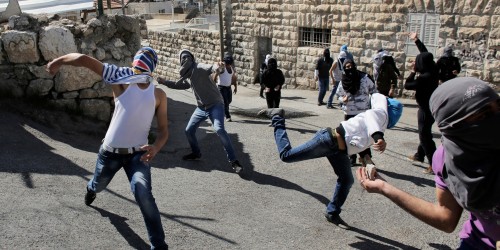 Palestinian protesters throw stones towards Israeli policemen during clashes in the Arab east Jerusalem neighbourhood of Ras al-Amud